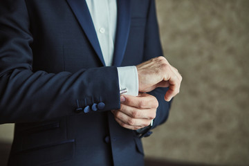 Businessman wears a jacket,male hands closeup,groom getting ready in the morning before wedding...