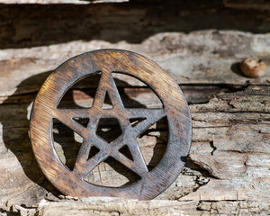Fototapeta na wymiar Wooden encircled pentagram symbol on fibrous tree bark in the forest. Five elements: Earth, Water, Air, Fire, Spirit.