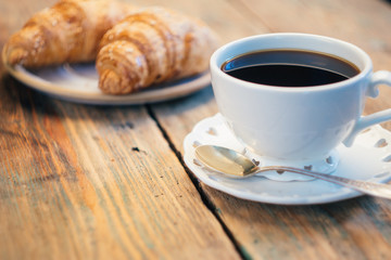 Black coffee and croissant. Typical French Breakfast (Petit Déjeuner) background.