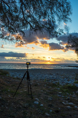 Camera taking picture film of sunrise over sea surface