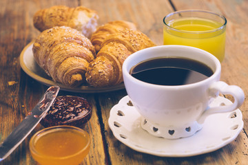 Black coffee and croissant with jam and orange juice. Typical French Breakfast (Petit Déjeuner) background.