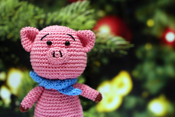 Fototapeta premium Chinese new year of the Pig, symbol 2019. Knitted toy piggy on christmas decorations background, Zodiac sign for greeting card