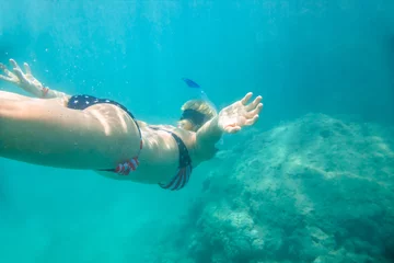 Fotobehang American flag bikini woman underwater snorkeling in the tropical sea with American flag bikini. Watersport activity in Hawaii. Tropical destination holiday travel. © bennymarty