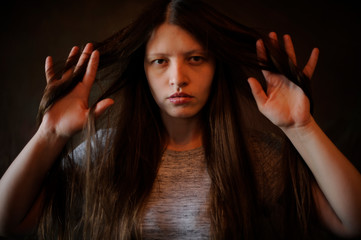 Beautiful girl with long hair like a witch poses for the camera on Christmas Eve