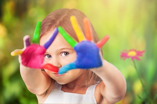 Little girl showing painted hands on  background