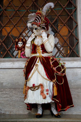 Carnival red-white mask and costume at the traditional festival in Venice, Italy