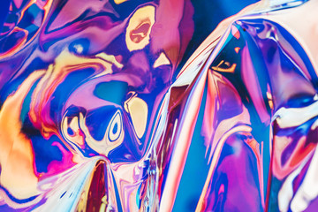 Bright holographic foil background. Multicolored and pastel trendy backdrop.