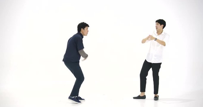 Group of young asian people having fun dancing like crazy at white background. People with party, celebration, enjoyment and new year concept. Slow Motion