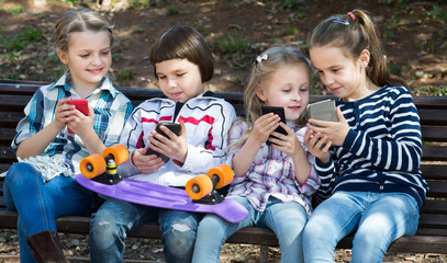 Portrait of junior kids playing with phones
