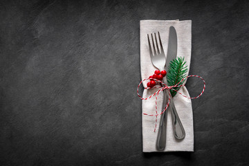 Christmas table place setting on dark slate background