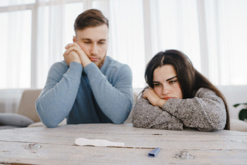 Unwanted pregnancy, contraception fail, safe concept. Frustrated couple checking a pregnancy test
