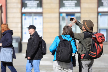 Para turystów z plecakami robi zdjęcia telefonem, smartfonem. - obrazy, fototapety, plakaty