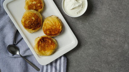 cottage cheese pancakes, tasty healthy breakfast, top view, grey stone background