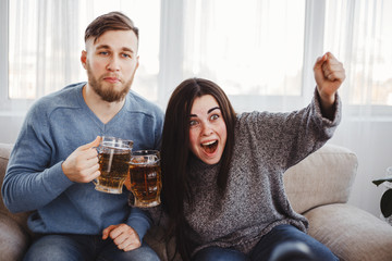 football fans cheer their favorite team. young people engrossed in watching sport match drinking beer shouting. two friends cheer for different teams, opposition, standoff