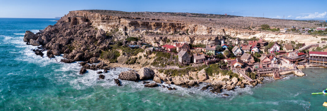 Aerial drone panorama photograph of the famous "Popeye Village" that sits on the rugged Mediterranean Sea coast of Malta.  Europe.  