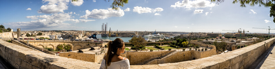Fototapeta na wymiar Woman overlooking the Grand Harbour of Valletta Malta