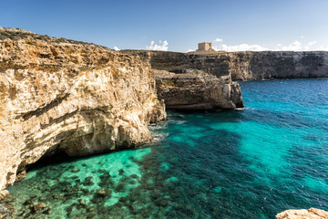 Medieval castle, St. Mary's Tower, atop the massive cliffs of Comino Island in the Mediterranean Sea.  Country of Malta.