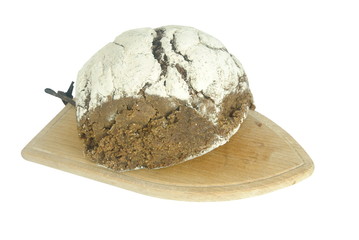 Broa, pão tradicional Português colocado em cima de uma tábua de corte de cozinha 