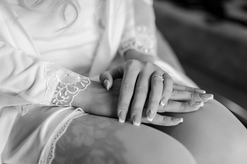 Close-up of tender ring on bride's hand with white nails