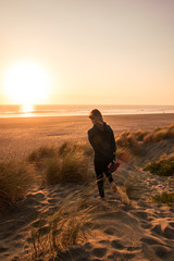 Woman walking at sunset on the beach
