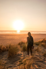 Woman walking at sunset on the beach