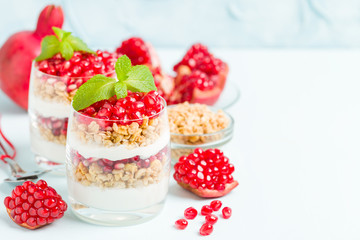 Pomegranate parfait - sweet organic layered dessert with granola flakes, yogurt and ripe fruit...