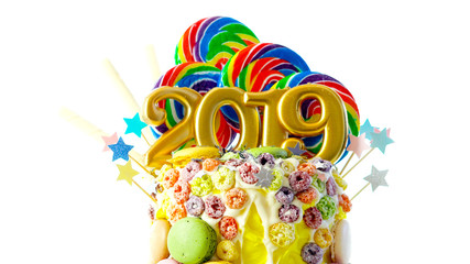 Happy New Year's candy land lollipop drip cake with 2019 candles on white background.