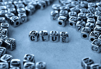 Clue - Word from Metal Blocks on Paper - Concept Photo on Table
