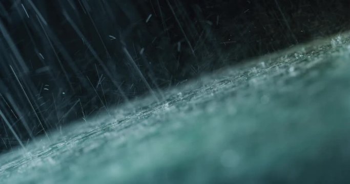 Super close up of a carglass while it&rsquo;s raining, the wipers are taking off the water from it. Concept: thunderstorm, car, weather. Shot on Red Camera 8K