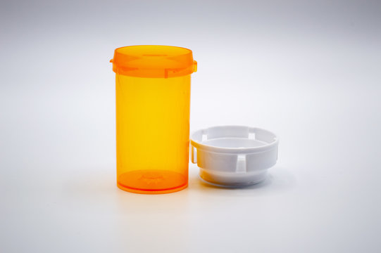 Empty yellow medicine bottle with a white cap isolated on a white background