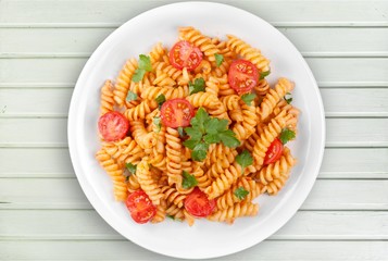 Spaghetti pasta with tomatoes and parsley on  table.