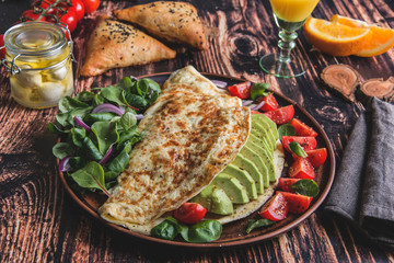 omelet with avocado, tomato, mozzarella cheese, orange juice, samsa. Healthy food