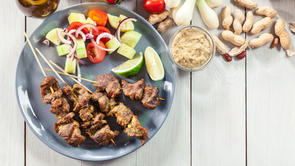 Traditional pork satay with peanut sauce and vegetables