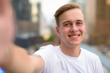 Personal point of view of handsome man taking selfie with phone
