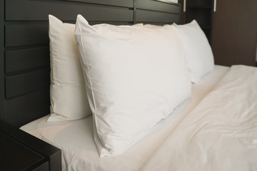 white pillow on bed with blanket in bedroom, closeup