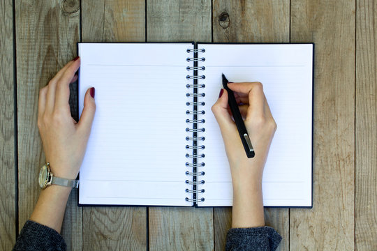 Woman hand writing on notebook with pen.
