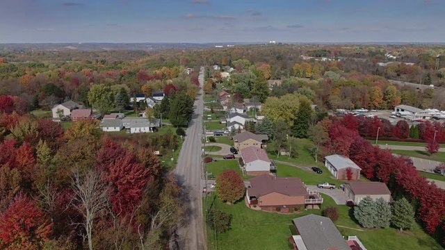 A fast aerial orbit around a typical Pennsylvania residential neighborhood on an Autumn day. Pittsburgh suburbs.  	