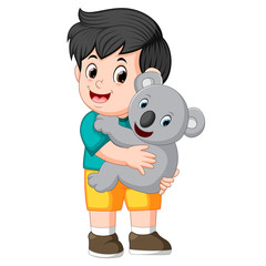 a little boy holding koala