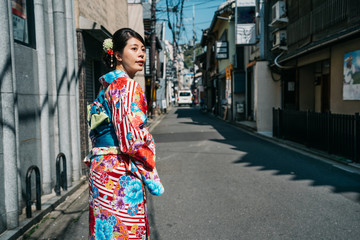 girl wearing traditional kimono walking in city