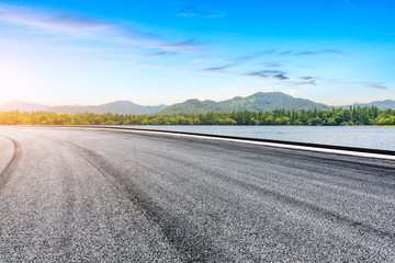 Asphalt road and beautiful mountain with lake