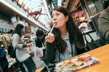 traveling girl excited eating fresh raw fish