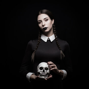 Young woman with pale skin with skull, gothic theme, mysteryous atmosphere