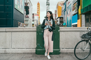 young girl with camera standing on the bridge