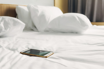 cellphone on white bed at morning