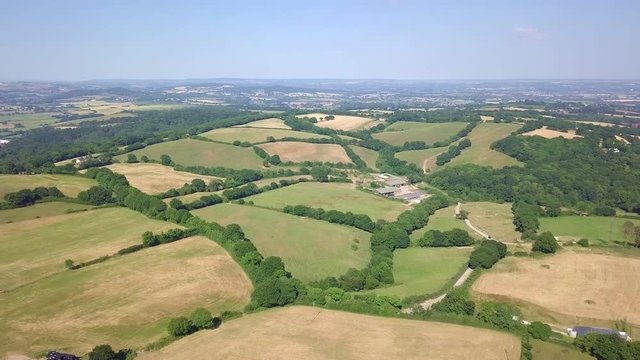 Aerial drone footage over rolling green farmland pastures in Exeter outskirts