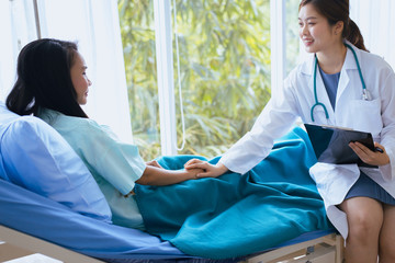 Obraz premium Hands woman doctor reassuring her female patient in hospital room,Doctor giving a consultation and encouragement to patient