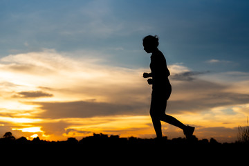 silhouette woman running alone at beautiful sunset in the park.