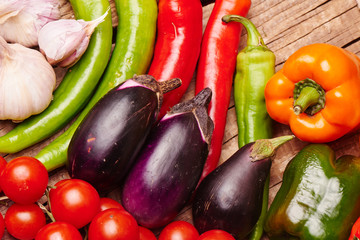 Cherry tomatoes, peppers, garlic, eggplants on a wooden table. Fresh organic vegetables..