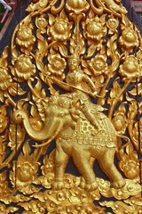 Golden Thai traditional  pattern wooden carving wall in Thailand ,Thai warrior (king) riding elephant for fighting at war