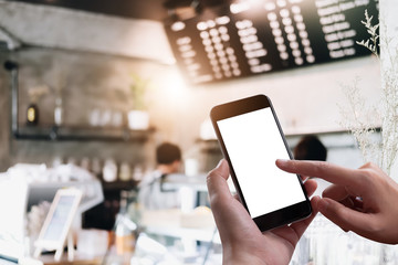 Close up Woman hand Using a Smart Phone with blank screen at coffee shop.